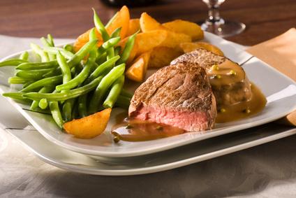 medium rare fried beef fillet in pepper sauce, with potato wedges and green beans