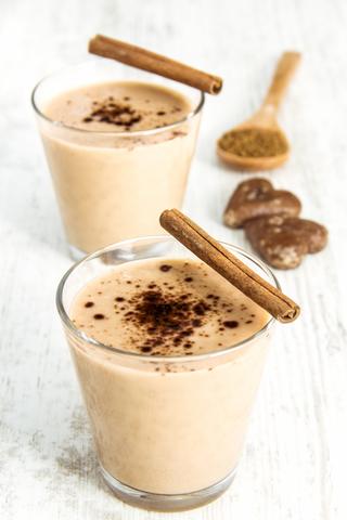 Delicious Milkshake with cinnamon and Cookies on Wooden Table