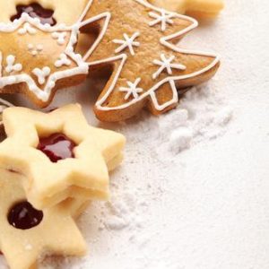 White wooden board and Christmas cookies and powdered sugar.