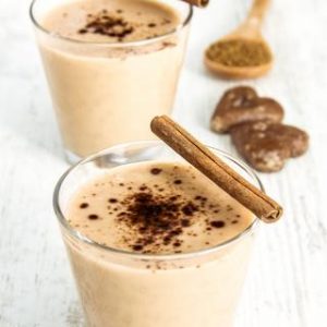 Delicious Milkshake with cinnamon and Cookies on Wooden Table