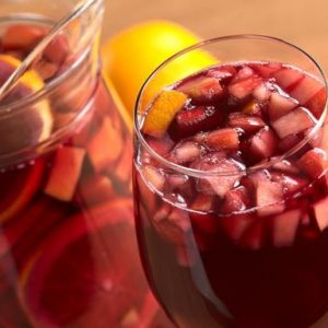 Refreshing red wine punch called sangria mixed with orange, apple, mango pieces served in wine glass (Selective Focus, Focus on the fruit pieces in the middle of the glass)